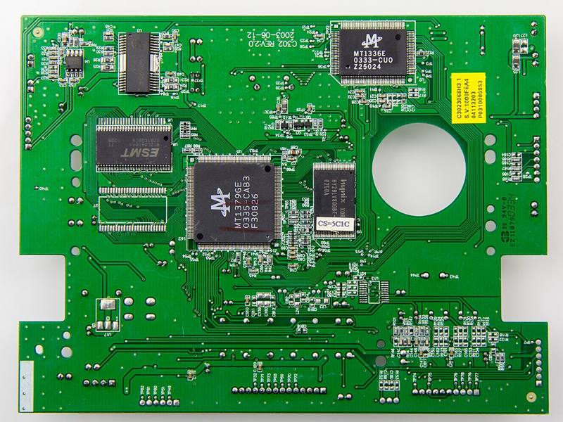 A green printed circuit board with components and gold-colored contacts
